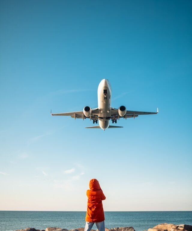 woman filming plane landing on phone